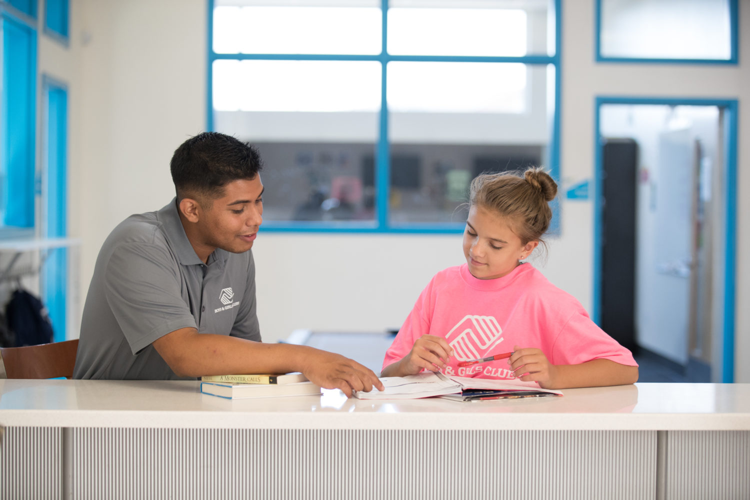 Boys and Girls Club Mentor Working with Young Girl on Homework