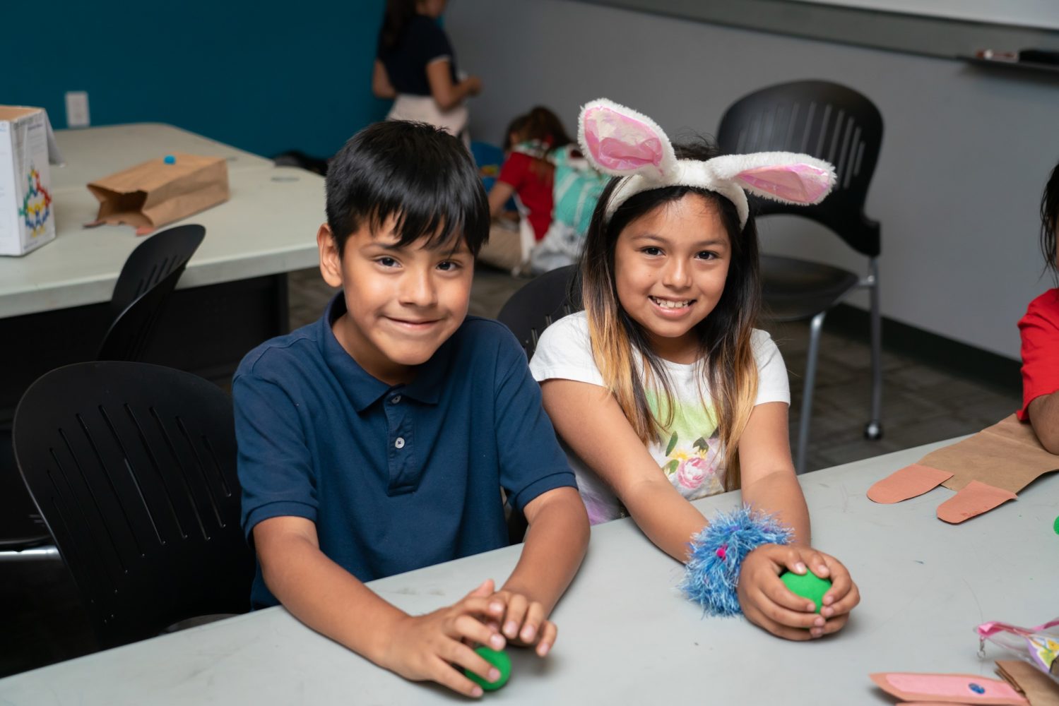 A boy and a girl doing Easter activities and smiling at the camera
